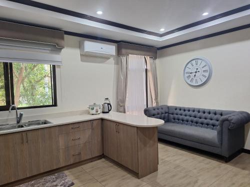 a kitchen with a couch and a clock on the wall at La Dolce Vita Villa in Santa Rosa