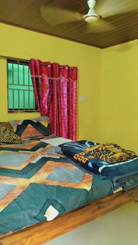 a bedroom with a bed with a colorful comforter at Deepu Guest house in Gokarna