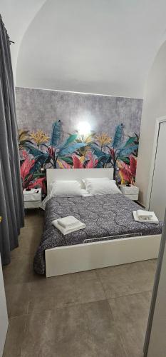 a bedroom with a large bed with a colorful wall at Fashion House Spaccanapoli in Naples