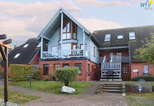 ein Haus mit einem Balkon an der Seite in der Unterkunft Ferienpark Seedorf Fischerhaus - Ferienwohnung 8 in Sellin