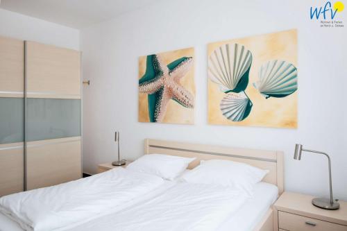 a bedroom with a bed with two pictures on the wall at Haus Oberlin Ferienwohnung 8 in Borkum
