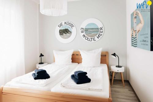 ein Schlafzimmer mit einem Bett mit blauen Handtüchern darauf in der Unterkunft Haus Oberlin Ferienwohnung 6 in Borkum