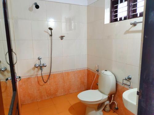 une salle de bain avec une douche, des toilettes et un lavabo dans l'établissement Agasthya, à Varkala