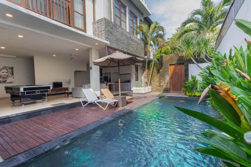 a swimming pool in the backyard of a house with a piano at The BALIem Villa in Jimbaran