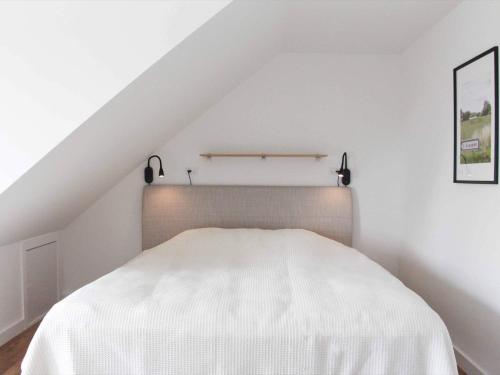 ein Schlafzimmer mit einem weißen Bett im Dachgeschoss in der Unterkunft 4 person holiday home in Svaneke in Svaneke