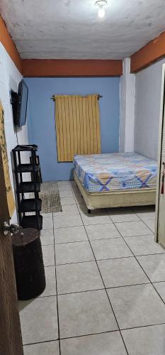 ein Zimmer mit einem Bett und einem Stuhl darin in der Unterkunft La Casa de Diego in Santa Ana