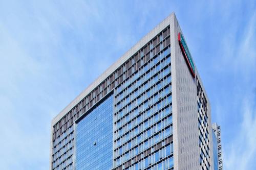 wysoki budynek z niebieskimi oknami na górze w obiekcie Courtyard by Marriott Suzhou w mieście Suzhou