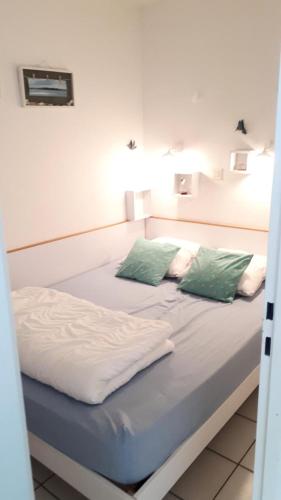 un lit avec deux oreillers dessus dans l'établissement Résidence Port du Crouesty - maeva Home - Appartement 2 Pièces 4 Personnes - Confort MAE-3009, à Arzon