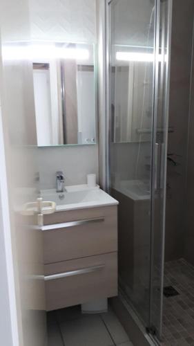 une salle de bain blanche avec un lavabo et une douche dans l'établissement Résidence Port du Crouesty - maeva Home - Appartement 2 Pièces 4 Personnes - Confort MAE-3009, à Arzon