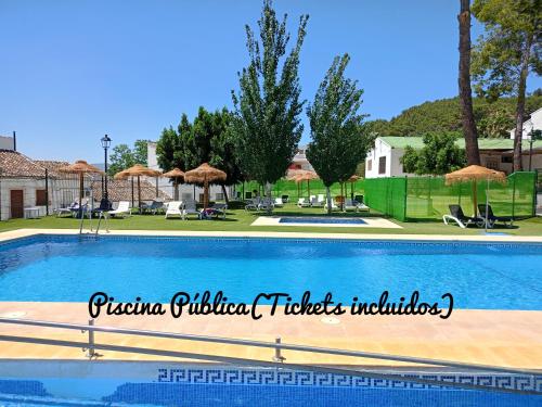 una gran piscina con sombrillas y un patio en Casa Montelucía en Montecorto