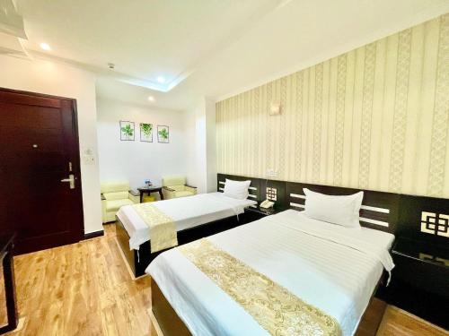 a hotel room with two beds and a table at Linh Phuong 2 Hotel in Can Tho