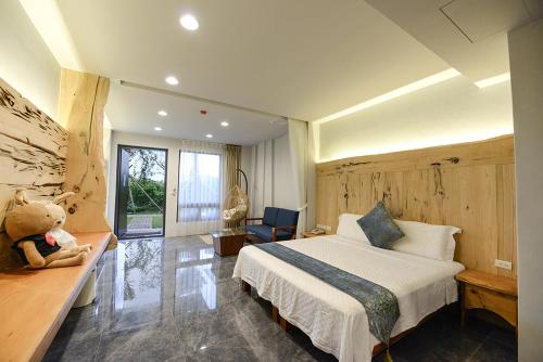 a bedroom with a bed and a teddy bear in it at Oceanic Pearl Resort in Xiaoliuqiu