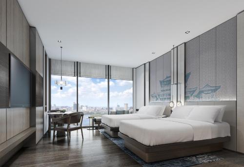 a hotel room with two beds and a desk and a table at Wuhan Marriott Hotel Wuchang in Wuhan