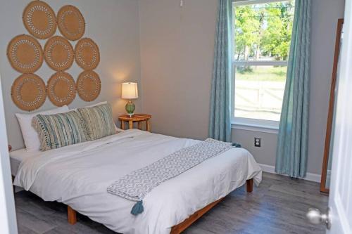 a bedroom with a large bed and a window at The Blue Pearl 6min to Downtown -Short Beach Drive in Pensacola
