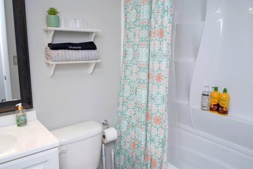 a bathroom with a toilet and a shower curtain at The Blue Pearl 6min to Downtown -Short Beach Drive in Pensacola