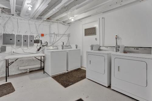 a laundry room with white appliances and a table at Modern Renovated & Comfy East Germantown Adobe in Philadelphia