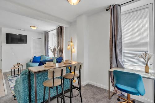 Una sala de estar con una mesa y sillas azules. en Renovated 2br In Germantown, en Filadelfia