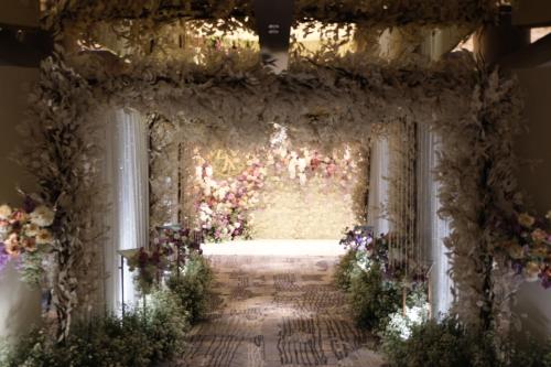 an aisle with flowers in a room with a window at Chatrium Grand Bangkok in Bangkok