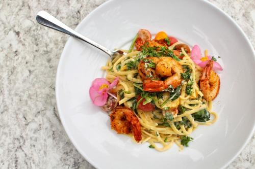 a white plate of shrimp pasta with a fork at Renaissance ClubSport Aliso Viejo Laguna Beach Hotel in Aliso Viejo