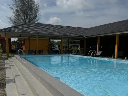 una gran piscina frente a un edificio en Capital O 90949 Pelangi Beach Resort Mersing en Mersing