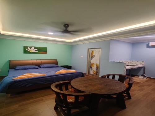 1 dormitorio con 1 cama, 1 mesa y 1 cama en Capital O 90949 Pelangi Beach Resort Mersing en Mersing