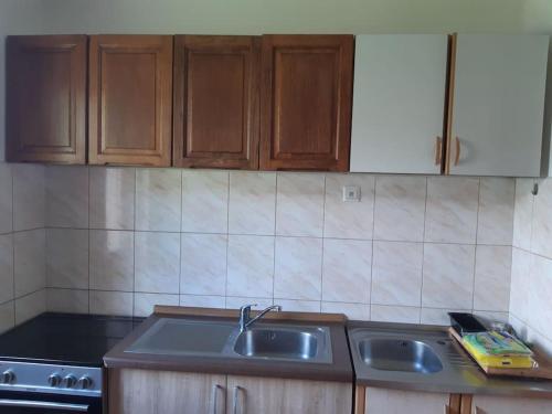 eine Küche mit Holzschränken und einem Waschbecken in der Unterkunft Wohnung nähe Stadtzentrum in Zenica