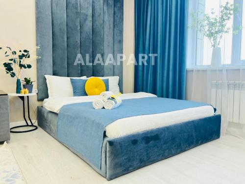 a blue bed with two stuffed animals on top of it at 396I1 Blue Horizon Apartments Sholpan city in Almaty