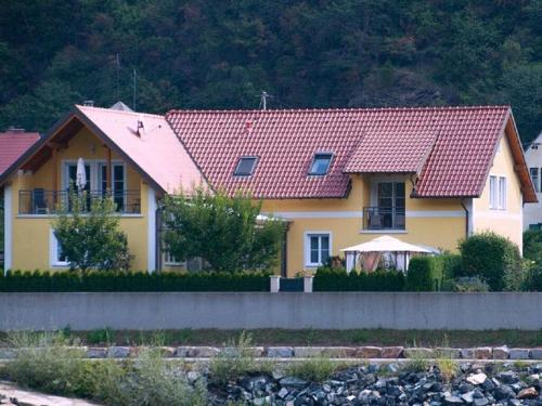 a yellow house with a red roof at Holiday apartment summer Wachau 2 in Spitz