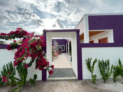 a house with purple and white walls and flowers at Villa Oneocean in Kondey