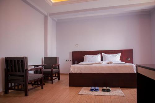 - une chambre avec un lit, une table et des chaises dans l'établissement Filagot Hotel, à Adama