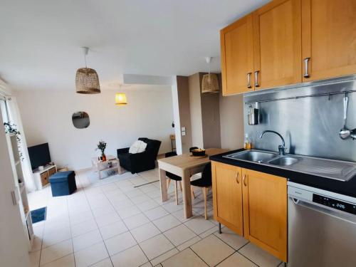 - une cuisine avec un évier et une table dans une chambre dans l'établissement Le cosy montpelliérain T3 avec parking, à Montpellier