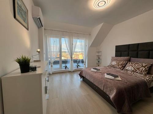 Un dormitorio con una cama grande y una ventana grande. en Panoramic view near Sofia Airport, en Sofía