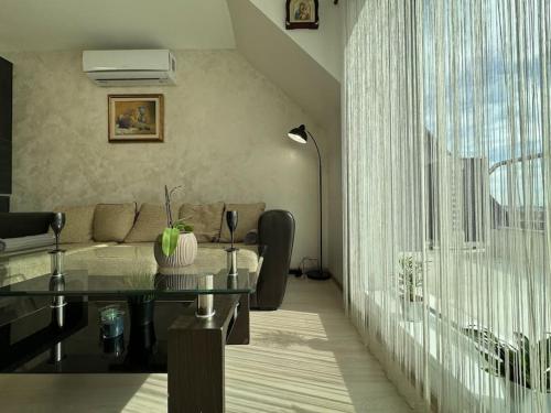 a living room with a couch and a glass table at Panoramic view near Sofia Airport in Sofia