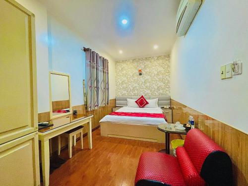 a bedroom with a bed and a desk and a red couch at Linh Phuong 2 Hotel in Can Tho