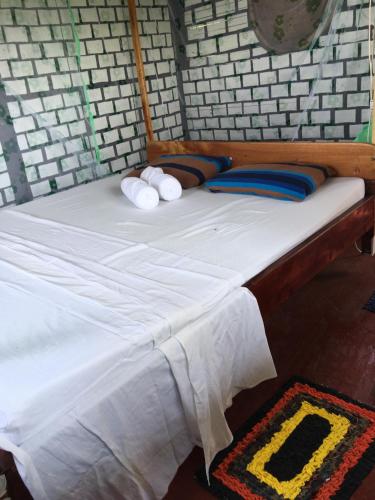 a bed with white sheets and pillows on it at Little birds in Tangalle