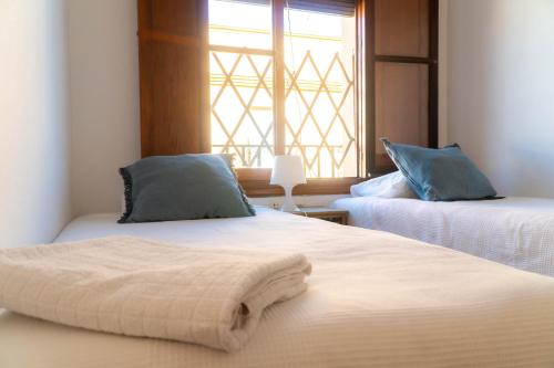 - une chambre avec 2 lits et une fenêtre dans l'établissement Light House Sherry, à Jerez de la Frontera