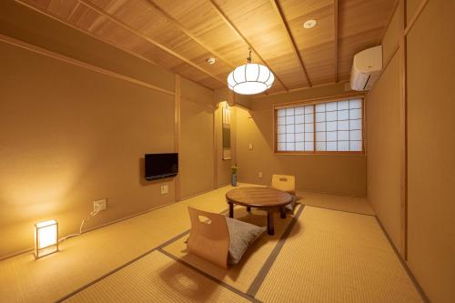 a living room with a table and a tv at Saju Kyoto 茶住 京都 in Kyoto
