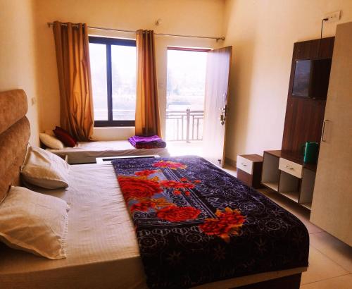 a bedroom with a large bed with flowers on it at Hotel Lake View Paradise in Uttarkāshi