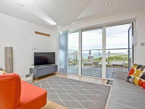 a living room with a couch and a television at 15 Ocean Gate Newquay in Crantock