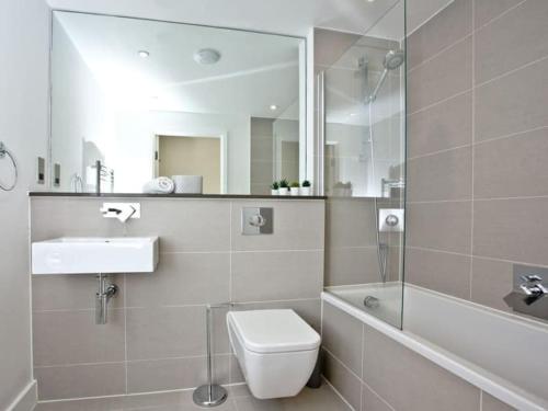 a bathroom with a toilet and a sink and a mirror at 15 Ocean Gate Newquay in Crantock