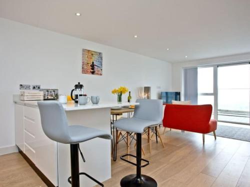 a kitchen with a table and chairs in a room at 15 Ocean Gate Newquay in Crantock