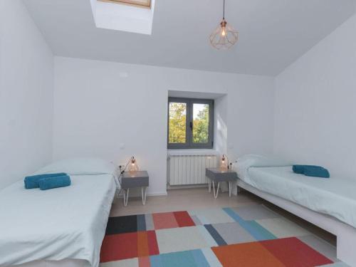1 Schlafzimmer mit 2 Betten und einem farbenfrohen Teppich in der Unterkunft Villa Stepan i with heated pool in Nedeščina
