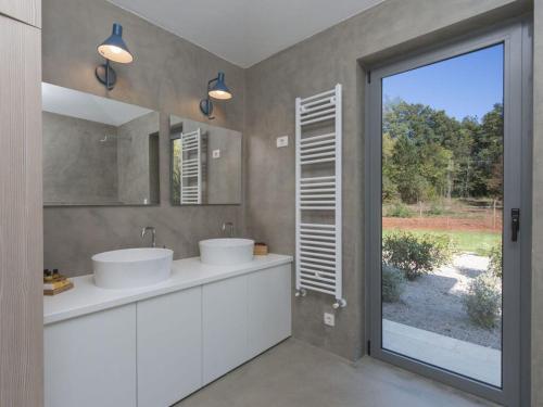 ein Badezimmer mit zwei Waschbecken und einer großen Glasschiebetür in der Unterkunft Villa Stepan i with heated pool in Nedeščina