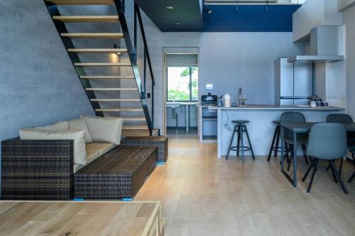 a living room with a couch and a kitchen at Yiyi Villa Awaji 淡路島西海岸夕日百選のvilla BBQ釣りゴルフ in Awaji