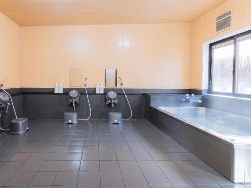 a bathroom with three toilets and a tub and a large tub at 民宿みやま in Ōno