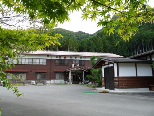 a building with a parking lot in front of it at 民宿みやま in Ōno