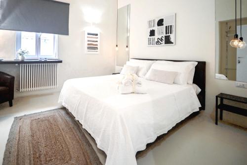 - une chambre dotée d'un lit blanc avec deux chaussures dans l'établissement 42 Zanardelli B&B, à Trani