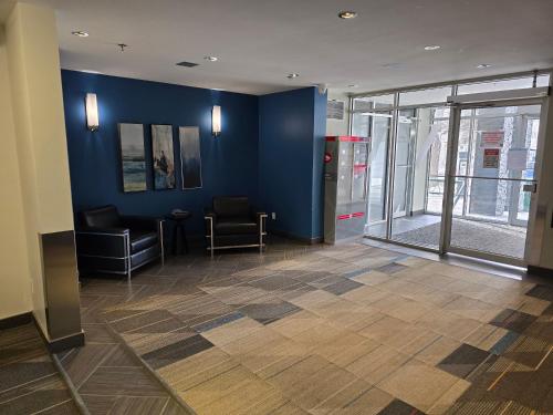 a lobby with a blue wall and chairs and a table at Smart Stylish Downtown Condo- 2 bedrooms in Saskatoon