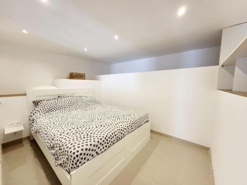 une chambre avec un lit dans une pièce blanche dans l'établissement Le TAMARIS ENTRE MER ET FORET, à La Seyne-sur-Mer