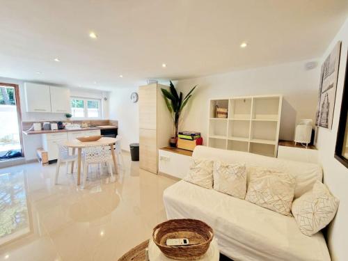 un salon avec un canapé blanc et une cuisine dans l'établissement Le TAMARIS ENTRE MER ET FORET, à La Seyne-sur-Mer